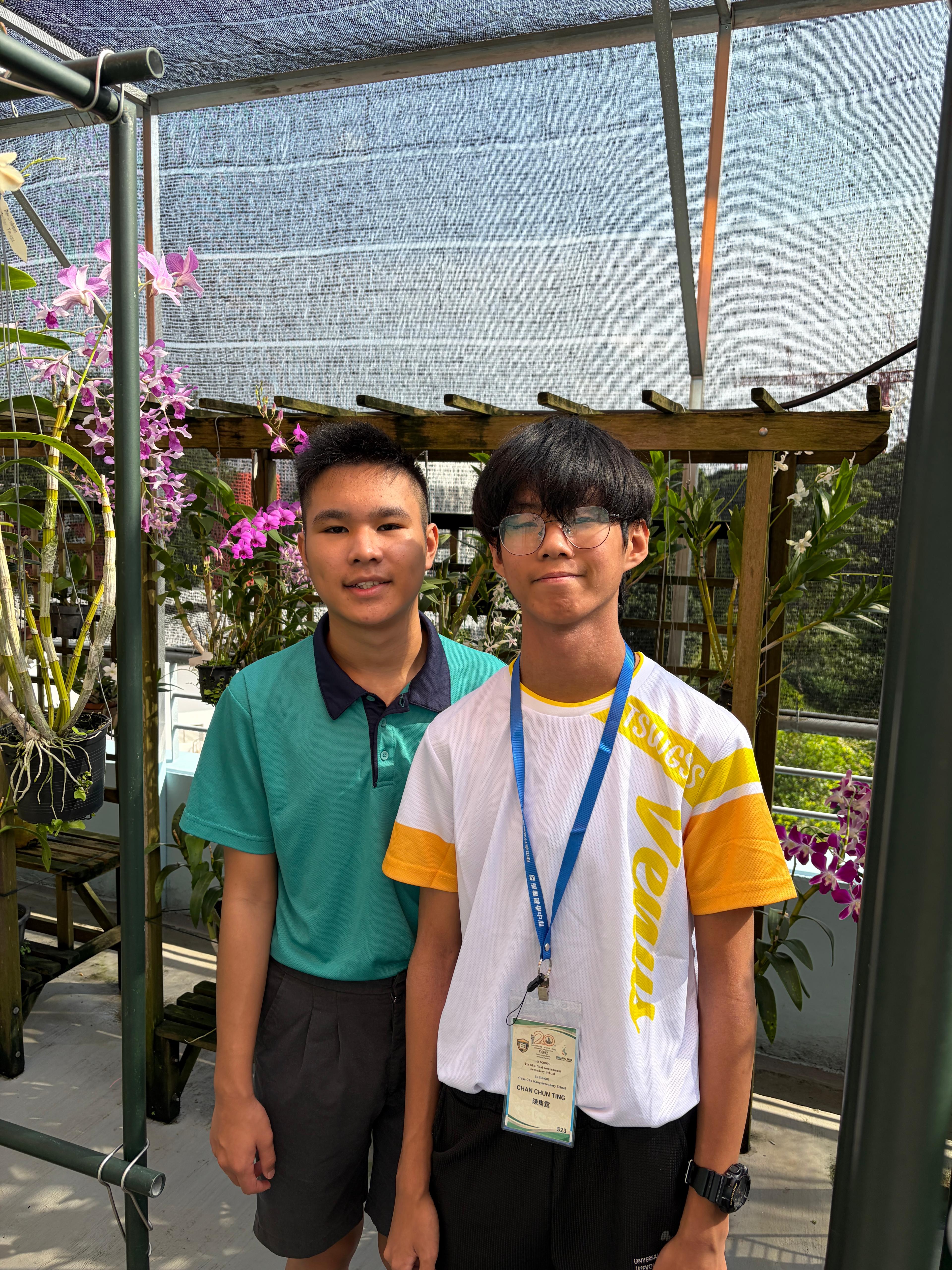 two boys standing amongst orchids